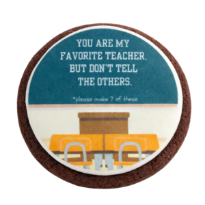 Sample Classy AF cookies saying "You're my favorite teacher. But don't tell the others. *please make 7 of these." written on a chalkboard with a teacher's desk
